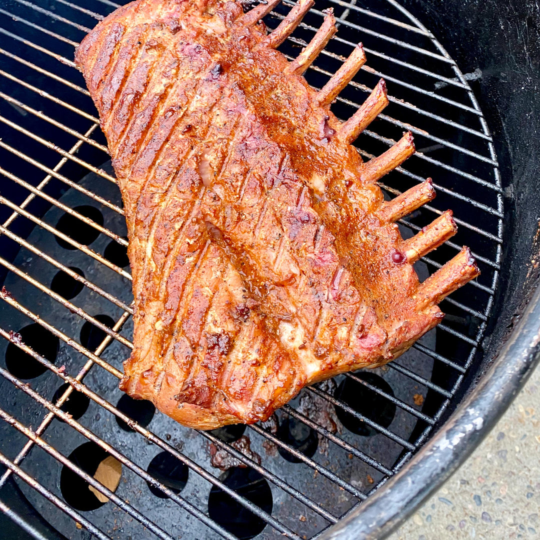 A rack of ribs is cooked on a 55 gallon Gateway Drum Smoker using the heat diffuser plate